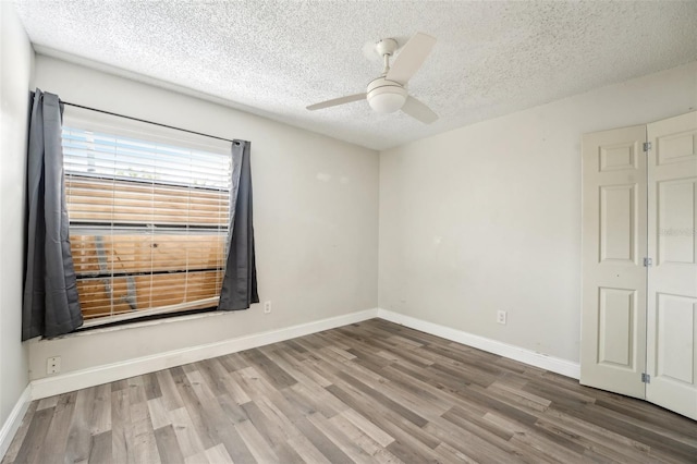 unfurnished room featuring baseboards, ceiling fan, and wood finished floors