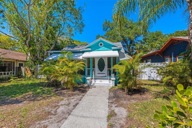 view of front of property featuring covered porch and fence