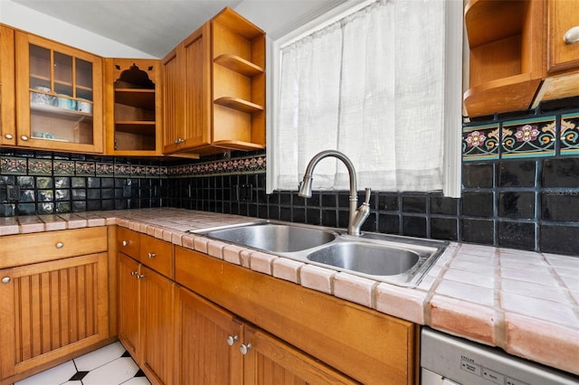 kitchen featuring tile countertops, a sink, brown cabinets, dishwasher, and open shelves