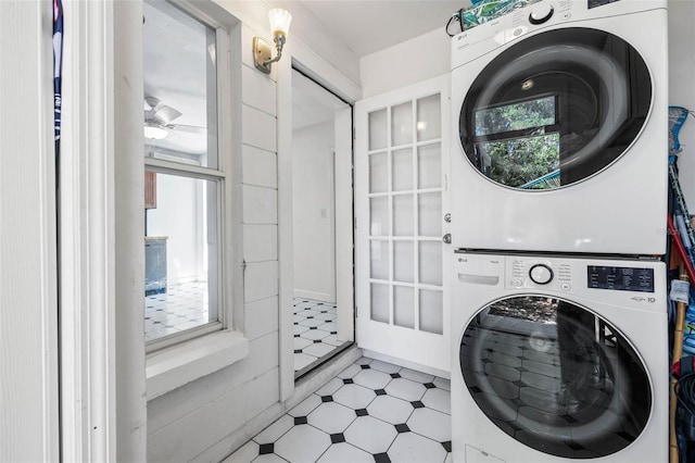 washroom featuring stacked washer and dryer, laundry area, and tile patterned floors