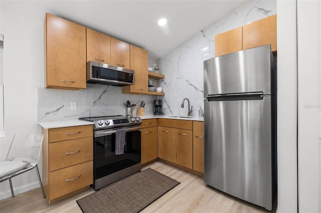 kitchen with stainless steel appliances, light countertops, a sink, and tasteful backsplash