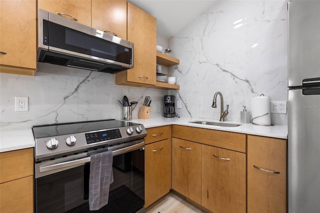 kitchen featuring backsplash, stainless steel appliances, a sink, and light countertops