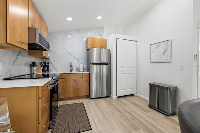 kitchen featuring stainless steel appliances, light countertops, decorative backsplash, brown cabinetry, and a sink