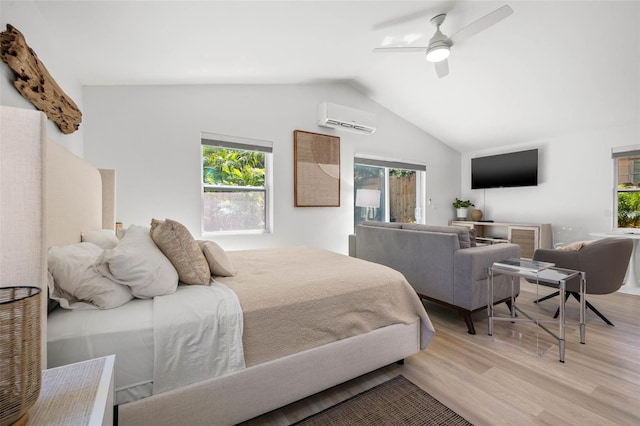 bedroom with lofted ceiling, an AC wall unit, light wood-type flooring, and a ceiling fan