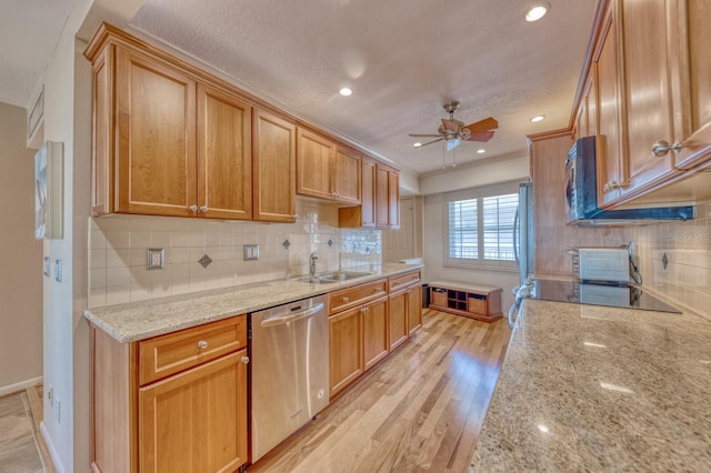 kitchen featuring tasteful backsplash, ceiling fan, stainless steel appliances, light wood-style floors, and a sink