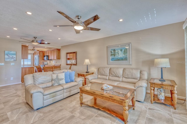 living room with recessed lighting, a textured ceiling, and baseboards