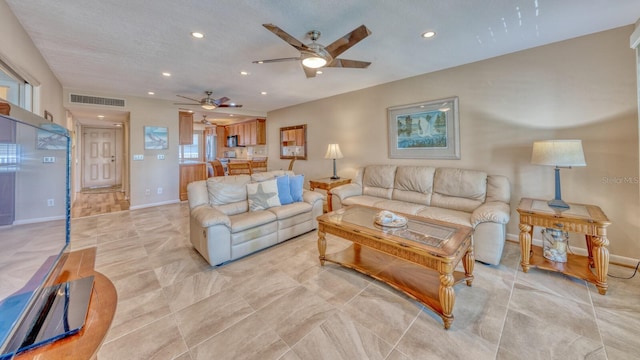 living area featuring baseboards, visible vents, a ceiling fan, and recessed lighting