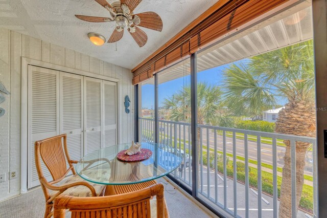 sunroom featuring ceiling fan and plenty of natural light