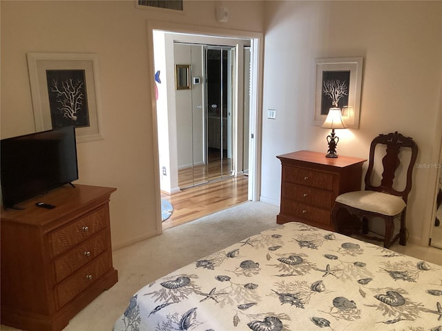 bedroom with light carpet, visible vents, and baseboards