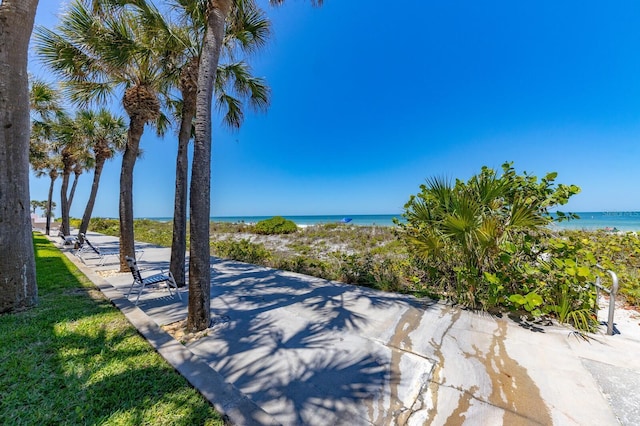 view of property's community with a beach view and a water view