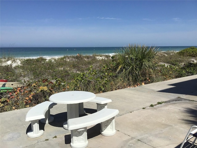 view of patio with a water view and a view of the beach