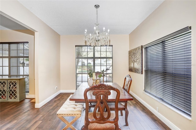 dining room with an inviting chandelier, baseboards, and wood finished floors