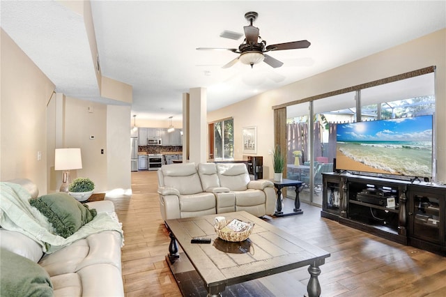 living room with light wood-style floors, visible vents, and ceiling fan