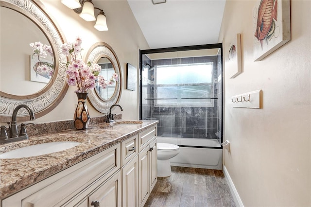 full bath featuring wood finished floors, a sink, toilet, and double vanity