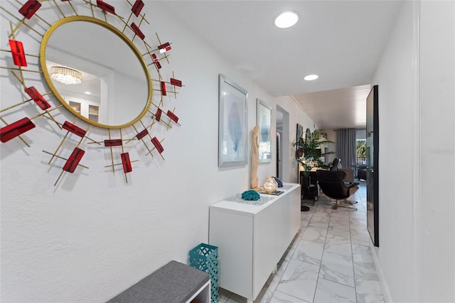 hallway featuring recessed lighting, marble finish floor, and baseboards