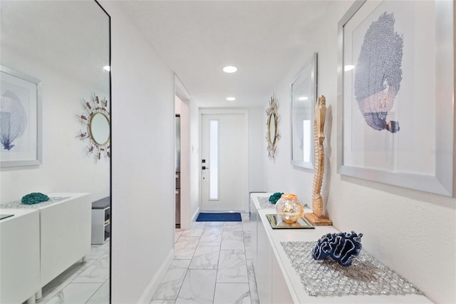 hall with recessed lighting, marble finish floor, and baseboards