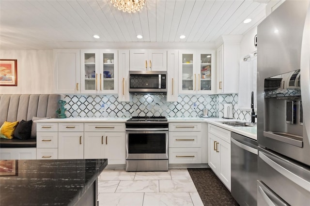 kitchen featuring wooden ceiling, white cabinetry, marble finish floor, appliances with stainless steel finishes, and decorative backsplash