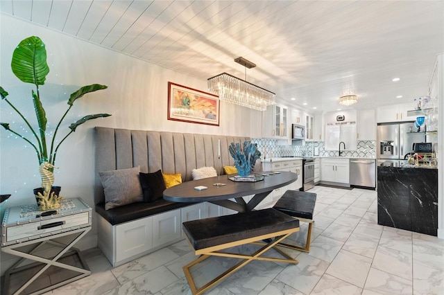 dining space with breakfast area, recessed lighting, and marble finish floor