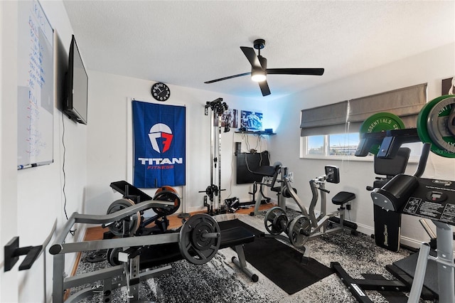 workout area featuring ceiling fan, baseboards, and a textured ceiling