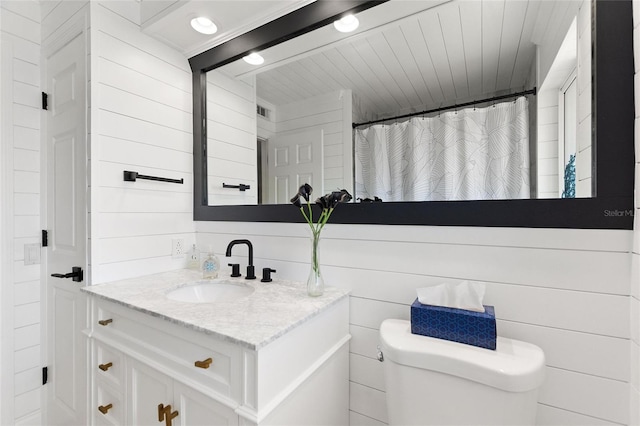 full bathroom featuring visible vents, toilet, wooden walls, vanity, and a shower with curtain