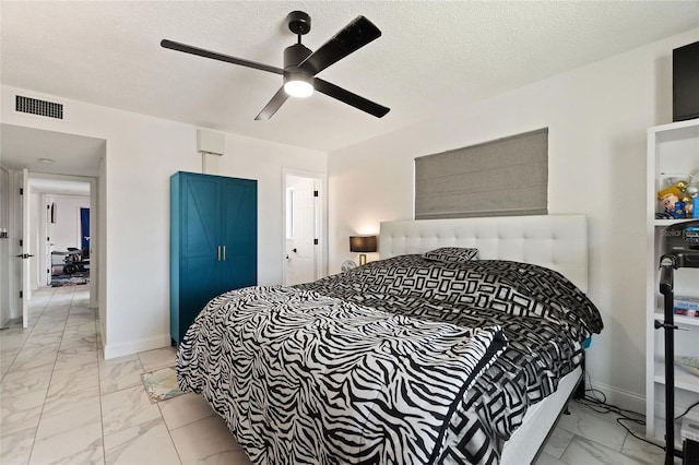 bedroom featuring marble finish floor, baseboards, visible vents, and a textured ceiling