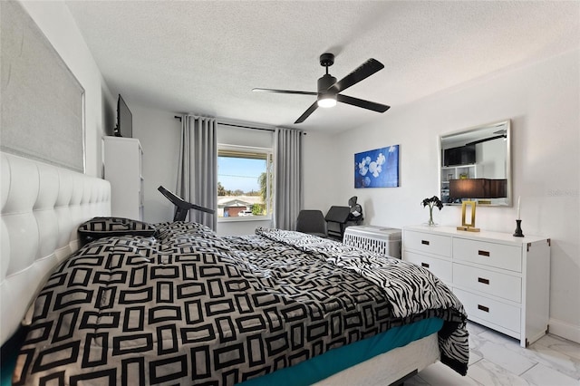 bedroom featuring a ceiling fan, marble finish floor, a textured ceiling, and baseboards