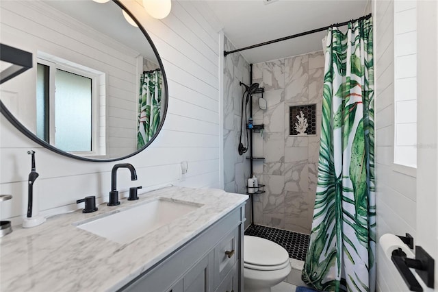 full bath featuring vanity, a tile shower, and toilet