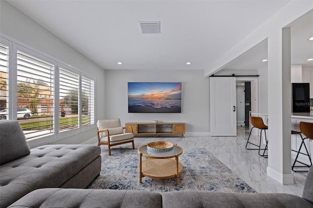 living room with visible vents, marble finish floor, baseboards, and a barn door