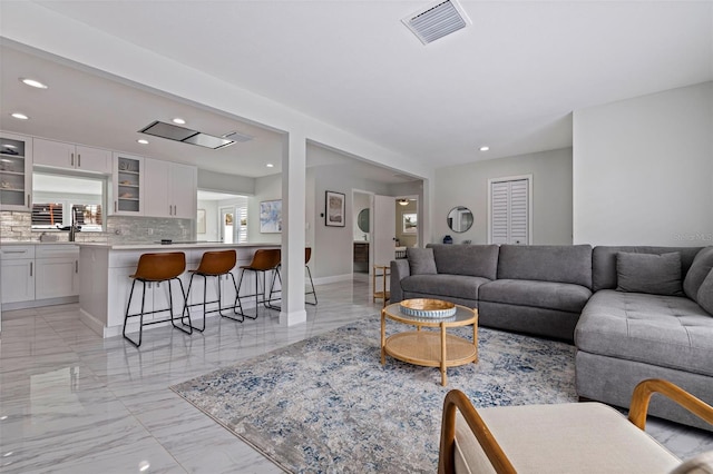 living area with recessed lighting, visible vents, marble finish floor, and baseboards