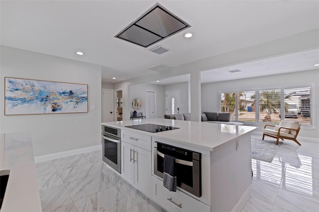 kitchen featuring baseboards, recessed lighting, oven, light countertops, and black electric stovetop