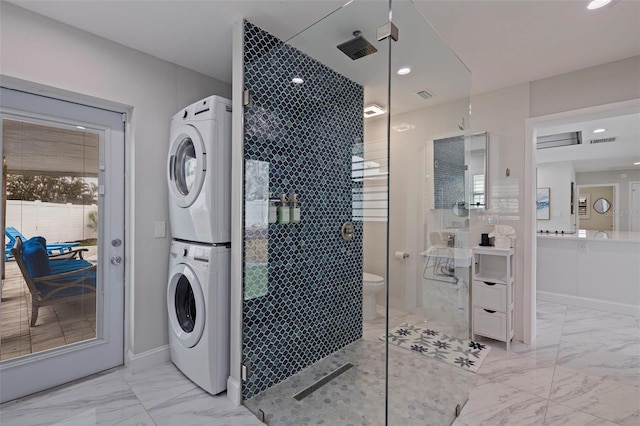 clothes washing area with recessed lighting, marble finish floor, stacked washer and clothes dryer, and laundry area