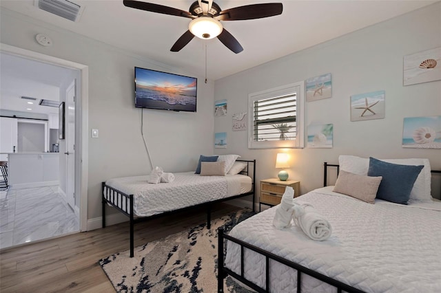 bedroom featuring visible vents, baseboards, light wood-style floors, and a ceiling fan