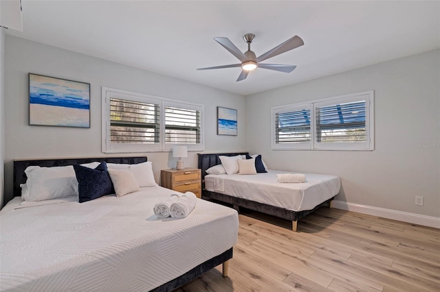 bedroom featuring ceiling fan, baseboards, and light wood-style floors