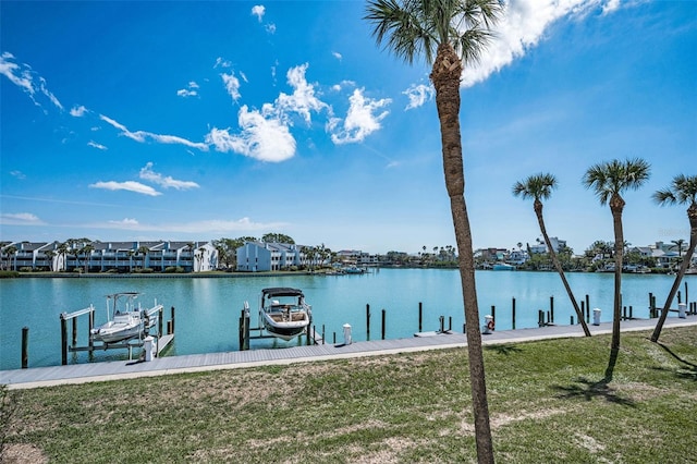 view of dock with a water view, a yard, and boat lift