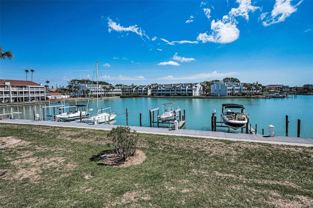 view of dock with a water view, boat lift, and a yard