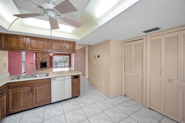 kitchen featuring light countertops, visible vents, a sink, a textured ceiling, and dishwasher