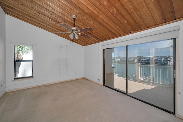 carpeted empty room with lofted ceiling, a water view, a ceiling fan, wooden ceiling, and baseboards