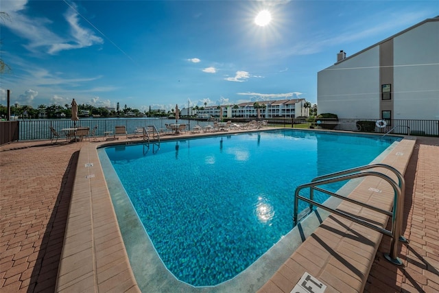 community pool with a patio and fence