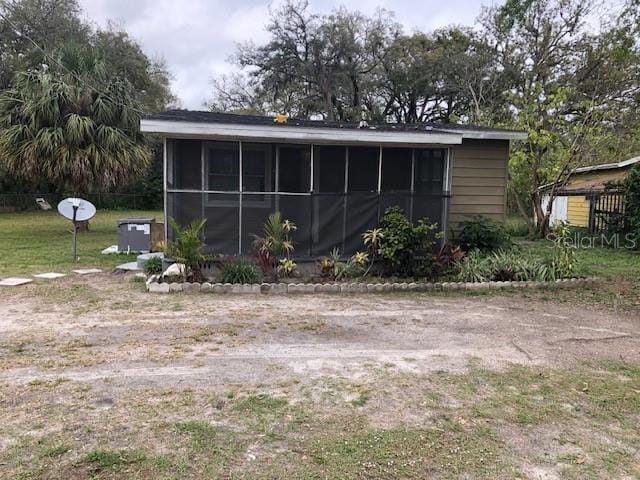 view of property exterior with a sunroom