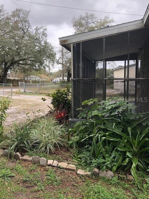 view of yard featuring fence and a sunroom