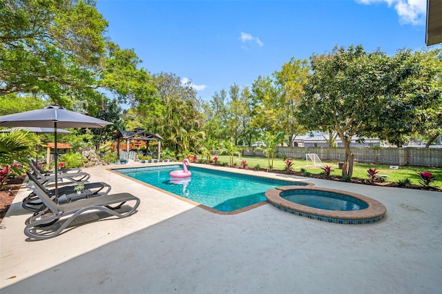 view of swimming pool with a patio area, a fenced backyard, a pool with connected hot tub, and a yard