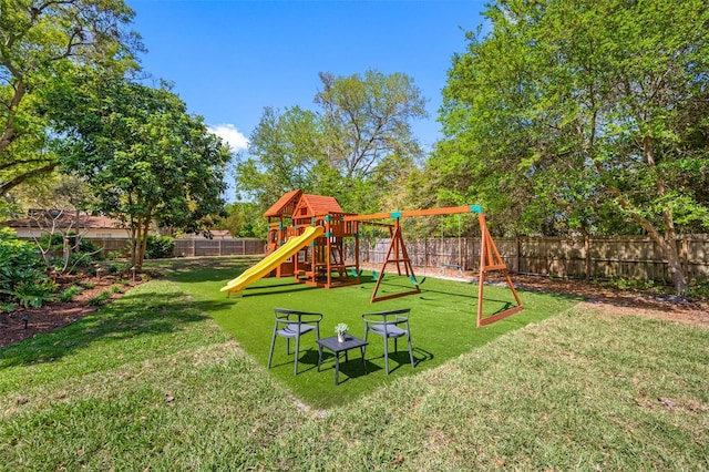 view of playground with a yard and a fenced backyard