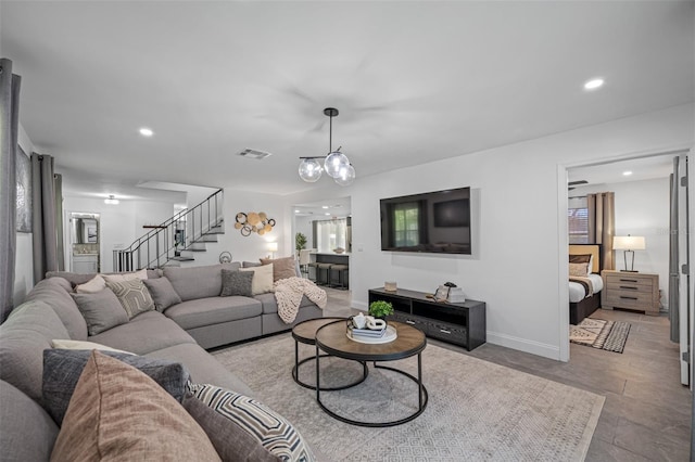 living area featuring baseboards, stairway, visible vents, and recessed lighting