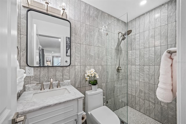 full bathroom with toilet, vanity, tile walls, a tile shower, and decorative backsplash