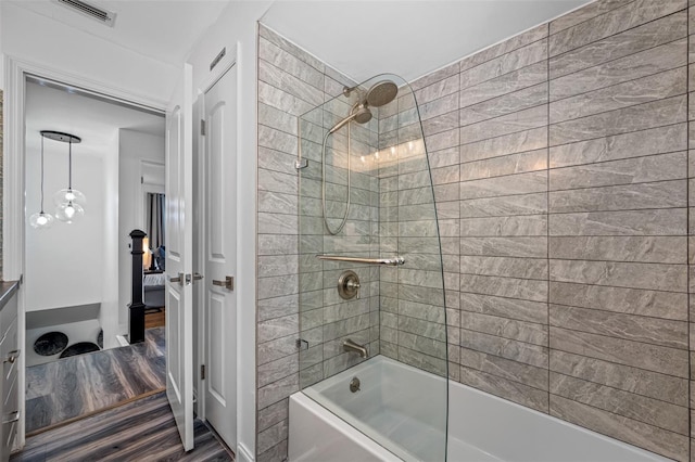 bathroom with wood finished floors, bathtub / shower combination, visible vents, and ensuite bathroom