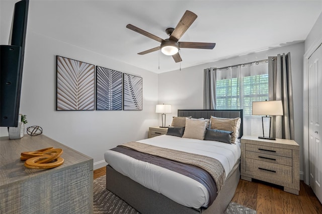 bedroom featuring a closet, ceiling fan, baseboards, and wood finished floors