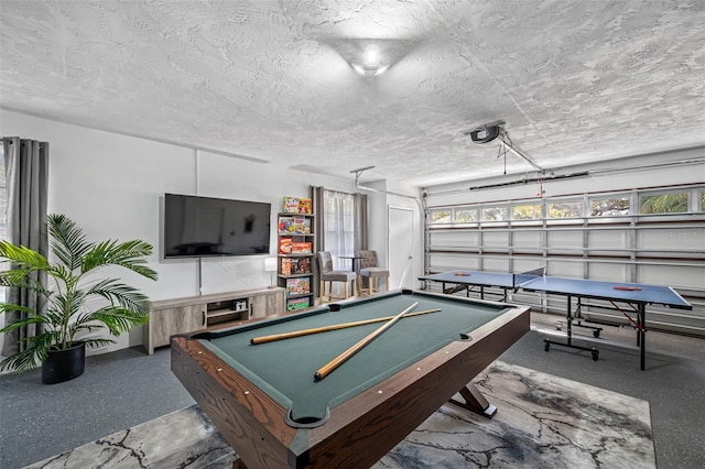 game room with a garage, billiards, and a textured ceiling