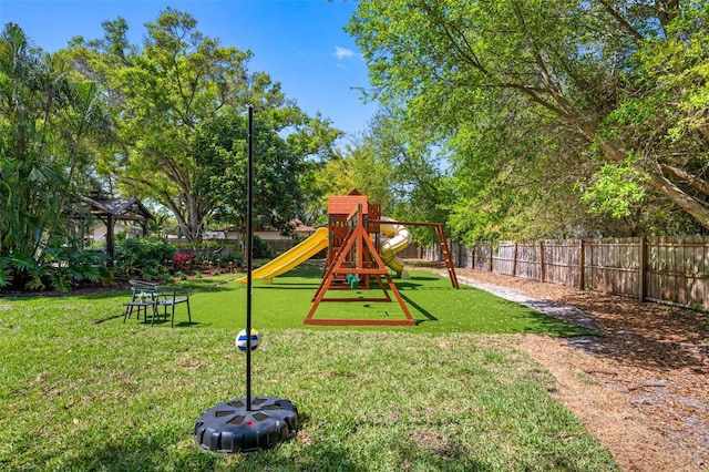 view of play area featuring a lawn and fence