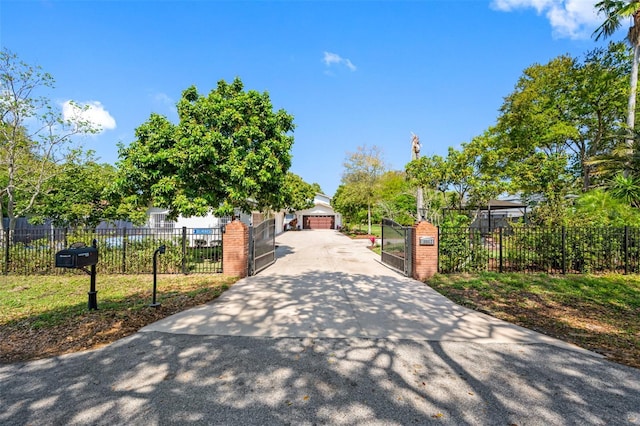 surrounding community featuring a garage, fence, and a gate