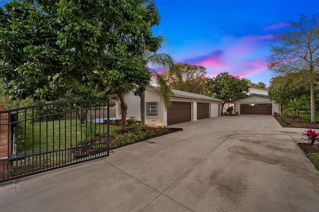 view of front of home featuring an outbuilding, stucco siding, fence, a garage, and driveway